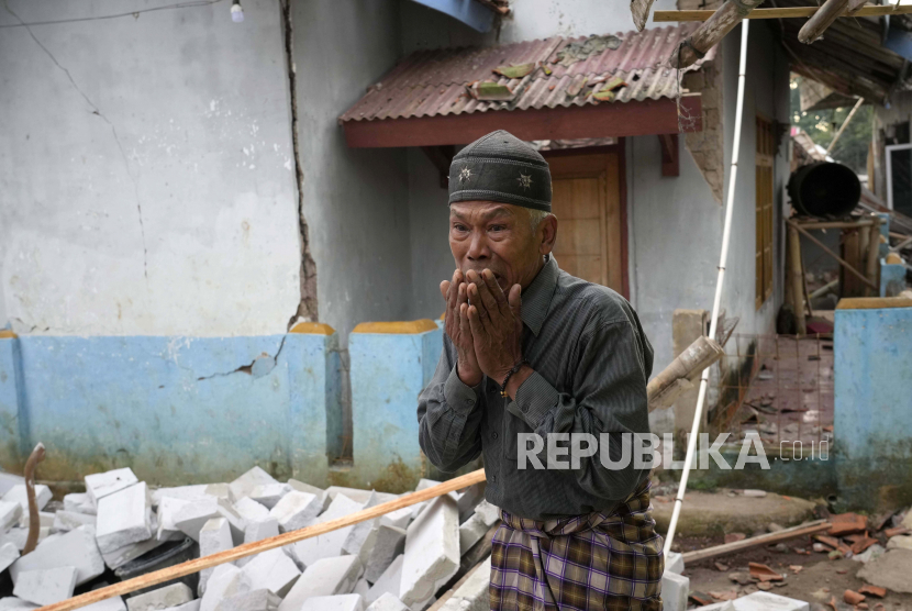 Seorang pria bereaksi saat memeriksa kerusakan akibat gempa Senin di Cianjur, Jawa Barat, Indonesia Selasa, 22 November 2022. Gempa telah merobohkan bangunan di pulau utama padat penduduk Indonesia, menewaskan sejumlah orang dan melukai ratusan lainnya.