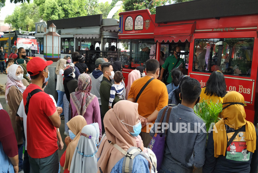 Warga Antre neik bus wisata Bandros (Bandung Tour on The Bus) di Alun-alun Kota Bandung, Ahad (6/2). Dalam sepekan ini kasus Covid-19 di Kota Bandung mengalami peningkatan. Sementara ini menurut Pusat data dan informasi Covid-19, Kota Bandung mencatat jumlah kasus mencapai 1.436 atau hampir tembus 1.500 dengan kasus harian mencapai 200 orang. Pemkot Bandung menghimbau agar masyarakat waspada dan tetap menerapkan protokol kesehatan dan bisa mengurangi mobilitas.