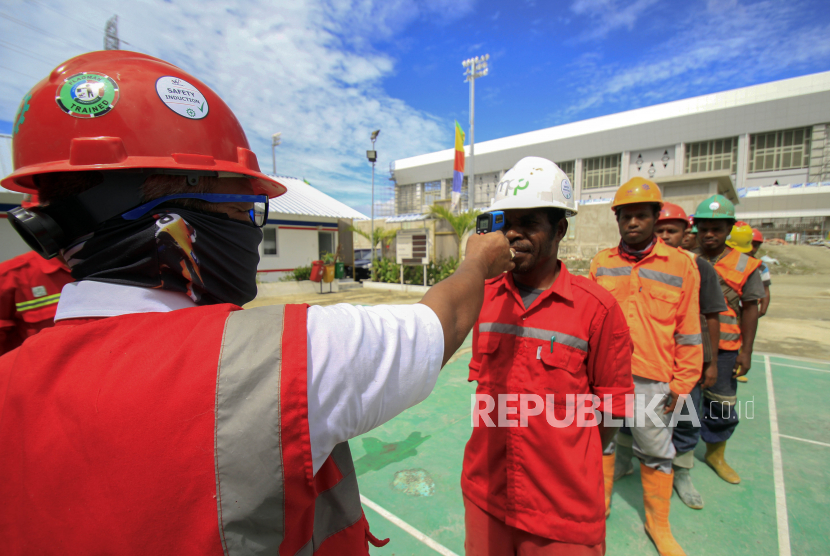 Petugas mengukur suhu pekerja sebelum beraktivitas di Venue Aquatic Kampung Harapan, Sentani, Jayapura, Papua, Rabu (01/4/2020). Pemprov Papua memperpanjang pembatasan sosial hingga 13 April 2020 untuk memutus penyebaran virus corona (COVID-19) di Papua