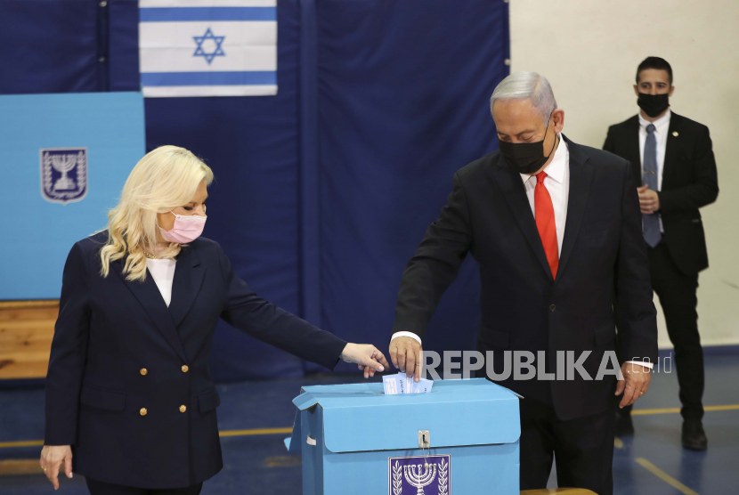 Perdana Menteri Israel Benjamin Netanyahu dan istrinya Sara memberikan suara mereka di tempat pemungutan suara ketika orang Israel memberikan suara dalam pemilihan umum, di Yerusalem, Selasa, 23 Maret 2021. 