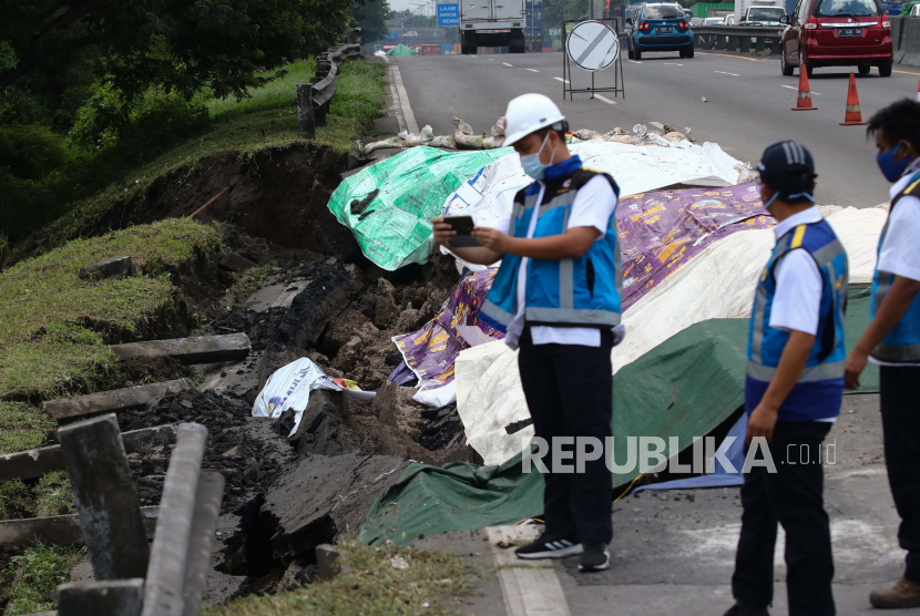 Petugas memeriksa jalan tol yang ambles di ruas tol Surabaya-Gempol KM 06+200, di Surabaya, Jawa Timur, Rabu (27/1/2021). Jalan tol ambles yang terjadi pada  Selasa (26/1) yang sebelumnya ditemukan retakan pada Senin (25/1) di lokasi tersebut mengakibatkan kemacetan lalu lintas yang sangat panjang. 