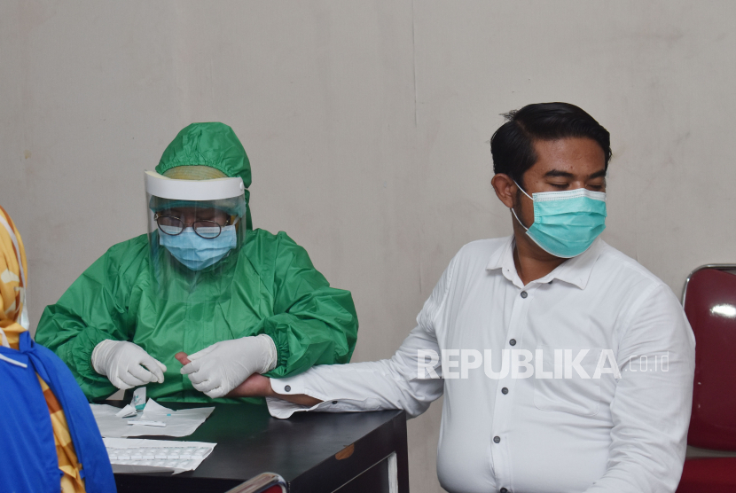 Petugas kesehatan mengambil sampel darah seorang anggota polisi saat tes diagnostik cepat (rapid test) COVID-19 di Polres Madiun, Jawa Timur.