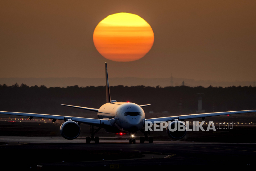  Sebuah pesawat terbang meluncur di bandara di Frankfurt, Jerman, saat matahari terbenam Selasa, 23 Februari 2021.