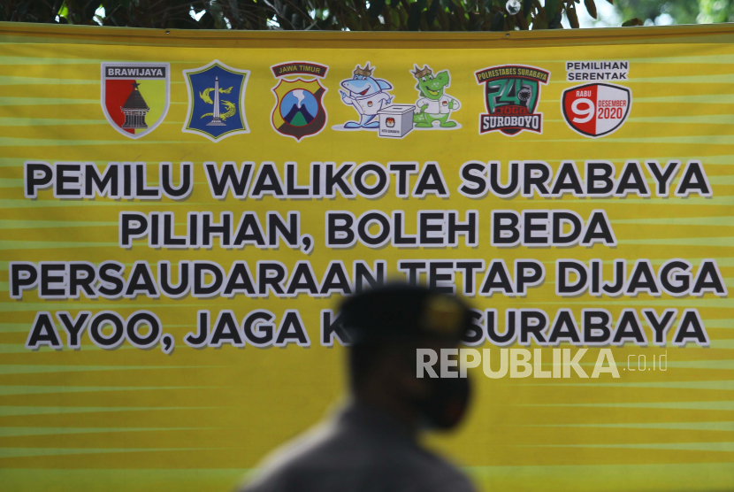 Polisi mengenakan masker saat berjaga di sekitar lokasi acara Deklarasi Kampanye Damai di Surabaya, Jawa Timur, Sabtu (26/9). (ilustrasi) 