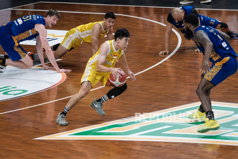 Pebasket Kesatria Bengawan Solo Andre Adrianno (tengah) berusaha melewati hadangan pebasket Satria Muda Pertamina Reynaldo Garcia Zamora (kanan) saat pertandingan Indonesian Basketball League (IBL) 2024 di Gor Sritex Arena, Solo, Jawa Tengah, Ahad (14/7/2024). Kesatria Bengawan Solo mengalahkan Satria Muda dengan skor 96-93.