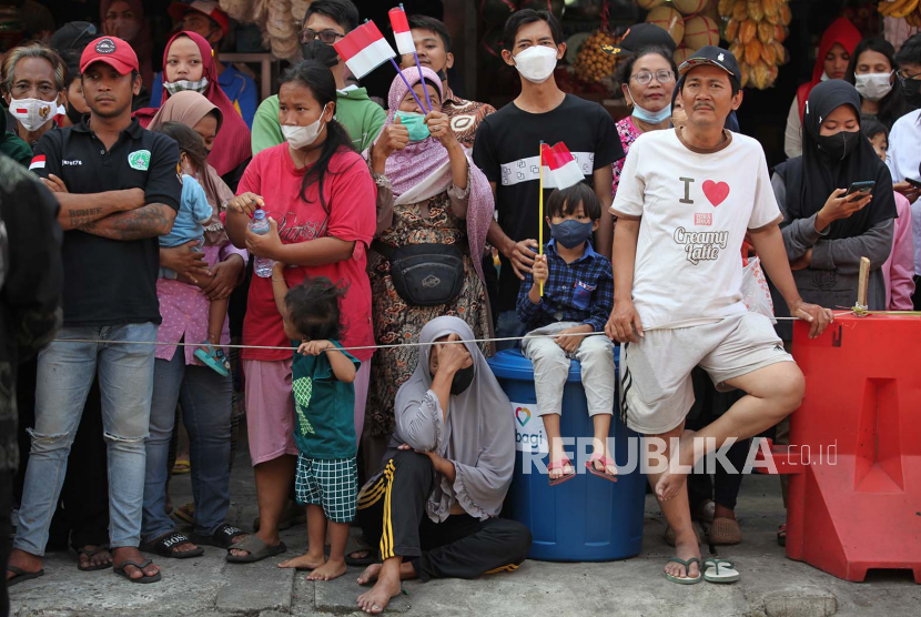 Sejumlah warga dan pedagang menunggu kedatangan Presiden Joko Widodo di Pasar Pucang Anom Surabaya, Jawa Timur, Ahad (21/8/2022). Presiden Joko Widodo memberikan sejumlah bantuan kepada pedagang dan peserta Program Keluarga Harapan.