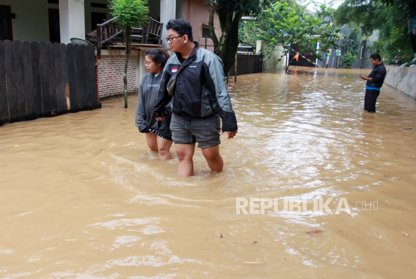 Warga melintasi banjir yang merendam permukiman (ilustrasi)