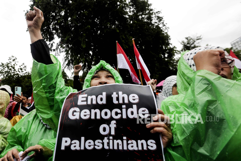 Muslim Indonesia memegang poster bertuliskan Akhiri Genosida Warga Palestina saat demonstrasi di depan Kedutaan Besar AS, Jakarta Pusat, Sabtu (9/3/2024).