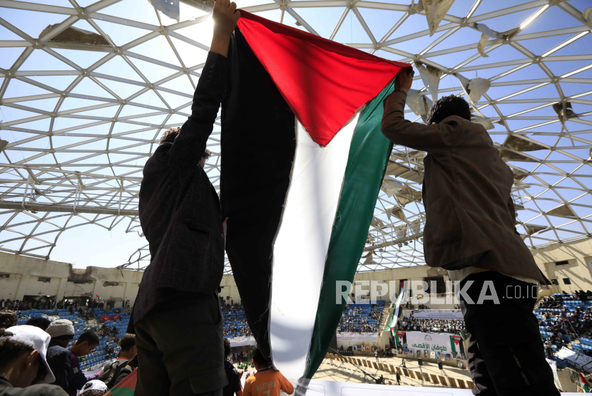 Ilustrasi warga mengibarkan bendera Palestina sebagai dukungan kepada mereka yang dizalimi Israel.