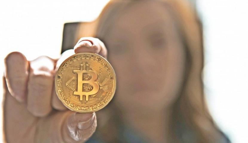 Woman Holding Bitcoin (Unsplash/André François McKenzie)