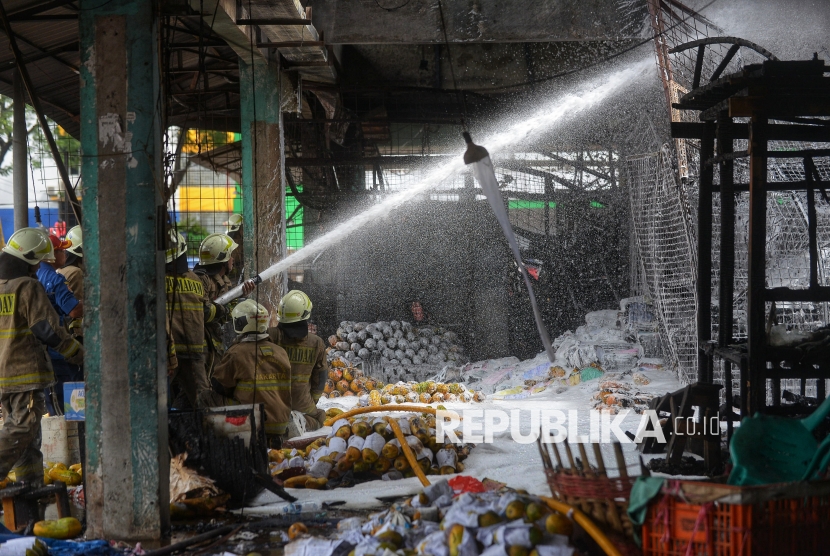 Petugas pemadam kebakaran memadamkan sisa api di kios los buah pepaya Pasar Induk Kramat Jati, Jakarta, Senin (15/12/2025). Kebakaran melanda los pepaya di Pasar Induk Kramat Jati, tersebut terjadi sekitar pukul 07.15 WIB. Material dagangan yang mudah terbakar diduga membuat api cepat membesar dan merambat ke lapak-lapak lainnya. Akibat peristiwa tersebut, sedikitnya 350 lapak pedagang hangus dilalap si jago merah. Untuk memadamkan api dan mencegah kebakaran meluas, petugas mengerahkan 19 unit mobil pemadam kebakaran dengan dukungan 95 personel ke lokasi kejadian. Hingga saat ini, api berhasil dikendalikan dan sudah padam.