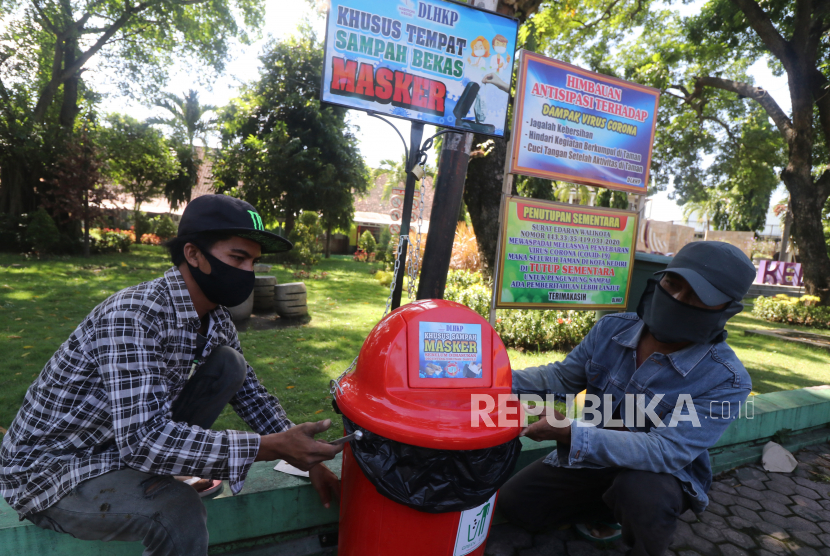 Pekerja memasang tempat sampah khusus untuk membuang masker bekas di pinggir jalan arteri di Kota Kediri, Jawa Timur, Selasa (12/5/2020). Sampah alat pelindung diri kerap dibuang sembarangan hingga berakhir di lautan.