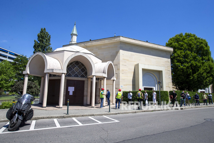  Para penyembah Muslim yang mengenakan topeng pelindung wajah sebagai tindakan pencegahan terhadap penyebaran antrian coronavirus COVID-19 di depan Masjid Jenewa, juga dikenal sebagai Masjid Petit-Saconnex, untuk sholat pertama setelah pembukaan kembali Masjid di Jenewa, Swiss, 1 Juni 2020.