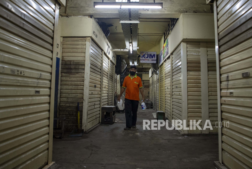 Petugas kebersihan berjalan di depan toko yang tutup di Pasar Asem Reges, Jakarta Barat, Selasa (21/7/2020). Pengelola Pasar Asem Reges menutup sementara pasar tersebut dari Senin (20/7) hingga Rabu (22/7) menyusul satu orang pedagang terkonfirmasi positif COVID-19 berdasarkan hasil tes usap (swab test). ANTARA FOTO/Nova Wahyudi/foc.