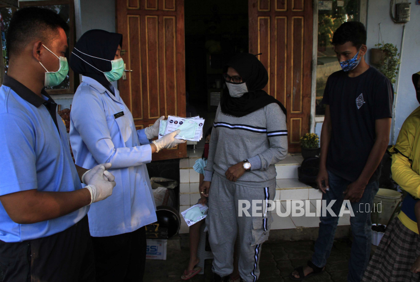 Petugas kesehatan dari Rumah Sakit Lanud El Tari Kupang membagikan masker kepada seorang ibu yang sudah menjalani tes cepat (rapid test) COVID-19 di rumahnya di Kupang, NTT, Jumat (4/9/2020). Tes cepat yang dilakukan langsung di rumah warga itu bertujuan untuk mencegah terjadinya penumpukan orang dalam jumlah yang banyak di suatu tempat tertentu. 