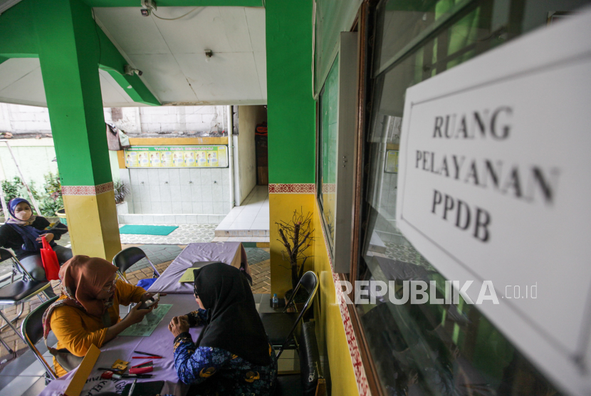 Guru melayani orang tua murid mengajukan pembuatan akun PPDB di SD Grogol Selatan 08, Kebayoran Lama, Jakarta, Senin (20/5/2024). Survei internal KPK menemukan adanya pungli oleh pejabat sekolah.