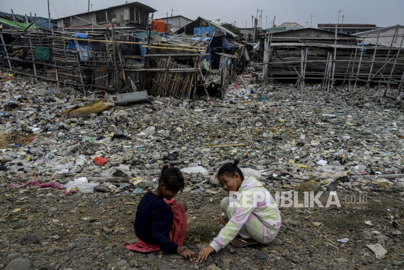Anak-anak mencari batu di dekat tumpukan sampah di kawasan Kali Baru, Cilincing, Jakarta. Dinas Lingkungan Hidup DKI menguji sampel air Kali Baru terkait temuan ikan mati.