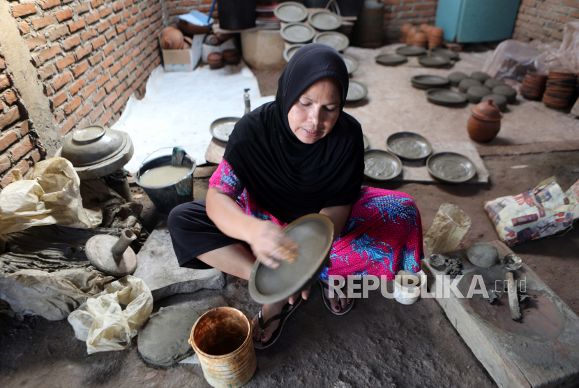 Seorang wanita bekerja di pot tanah liat di bengkel gerabah tradisional di tengah pandemi di Banda Aceh, Indonesia, 06 Januari 2022.