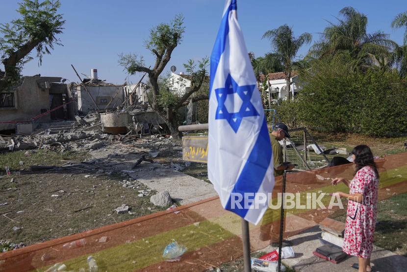 Seorang tentara Israel memeriksa rumah ibunya yang rusak karena serangan roket dari Gaza di Tel Aviv.