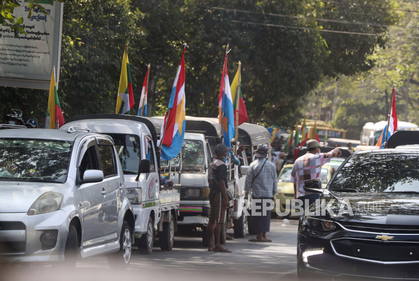  Pendukung militer Myanmar berkumpul di dekat truk yang dihiasi dengan bendera militer, bendera agama Buddha, dan bendera nasional Senin, 1 Februari 2021, di Yangon, Myanmar. Televisi militer Myanmar mengatakan Senin bahwa militer mengambil kendali negara selama satu tahun, sementara laporan mengatakan banyak politisi senior negara itu termasuk Aung San Suu Kyi telah ditahan.
