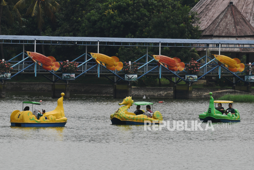 Pengunjung menaiki perahu di danau area TMII, Jakarta, Ahad (12/9/2021). Pengelola mulai membuka dua wahana di Taman Mini Indonesia Indah (TMII) yakni Taman Reptilia dan Taman Burung untuk rekreasi masyarakat saat masa Pembatasan Kegiatan Masyarakat (PPKM) Level 3 di Jakarta. 
