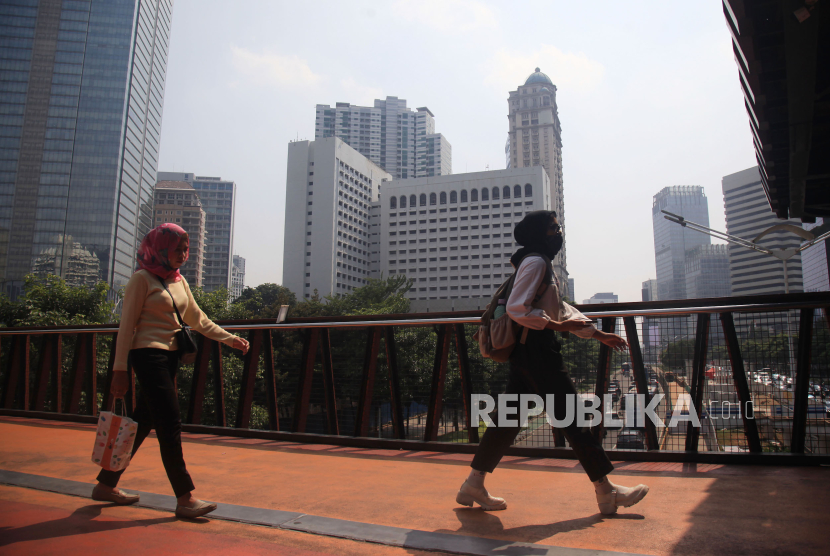 Warga melintas memakai masker untuk melindungi diri dari debu, di Jembatan Penyeberangan Sepeda (JPS) sekaligus Jembatan Penyeberangan Orang (JPO) di Jalan Sudirman,Jakarta, Selasa (8/8/2023). Pemprov DKI Jakarta mengimbau warga menggunakan masker untuk mengantisipasi polusi udara di Ibu Kota akibat polusi udara Jakarta dinilai sangat buruk.  