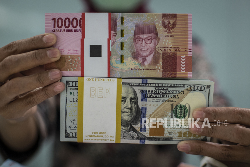 Karyawan menunjukkan uang rupiah dan dolar AS di Kantor Cabang Plaza Mandiri, Jakarta, Rabu (18/3/2020). in atau 0,93 persen ke posisi Rp15.223 per dolar AS. (ANTARA/Aprillio Akba)