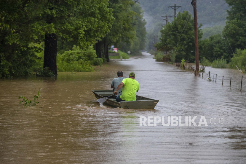 Orang-orang mengendarai bpsy di sepanjang Jalan Wolverine yang banjir di Breathitt County, Ky., pada Kamis, 28 Juli 2022. Hujan deras telah menyebabkan banjir bandang dan tanah longsor saat badai melanda bagian tengah Appalachia. Gubernur Kentucky Andy Beshear mengatakan ini adalah salah satu banjir terburuk dalam sejarah negara bagian.