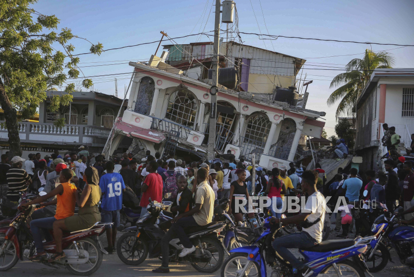  Orang-orang berkumpul di luar Hotel Petit Pas, yang hancur akibat gempa di Les Cayes, Haiti, Sabtu, 14 Agustus 2021. Gempa berkekuatan 7,2 SR melanda Haiti pada Sabtu, dengan pusat gempa sekitar 125 kilometer (78 mil) barat ibu kota Port-au-Prince, kata Survei Geologi AS.