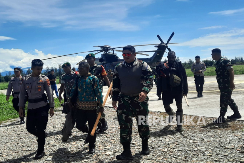 Anggota TNI-Polri yang tergabung dalam Satgas Operasi Damai Cartenz mengevakuasi sejumlah warga Kampung Alama Nduga, Nduga, Papua Pegunungan, dengan menggunakan helikopter saat tiba di Bandara Timika, Papua Tengah, Papua, Senin (20/02/2023). Sedikitnya 18 warga dievakuasi dan diungsikan ke Mimika imbas dari ancaman Kelompok Kriminal Bersenjata (KBB) pimpinan Egianus Kogoya di wilayah Nduga.