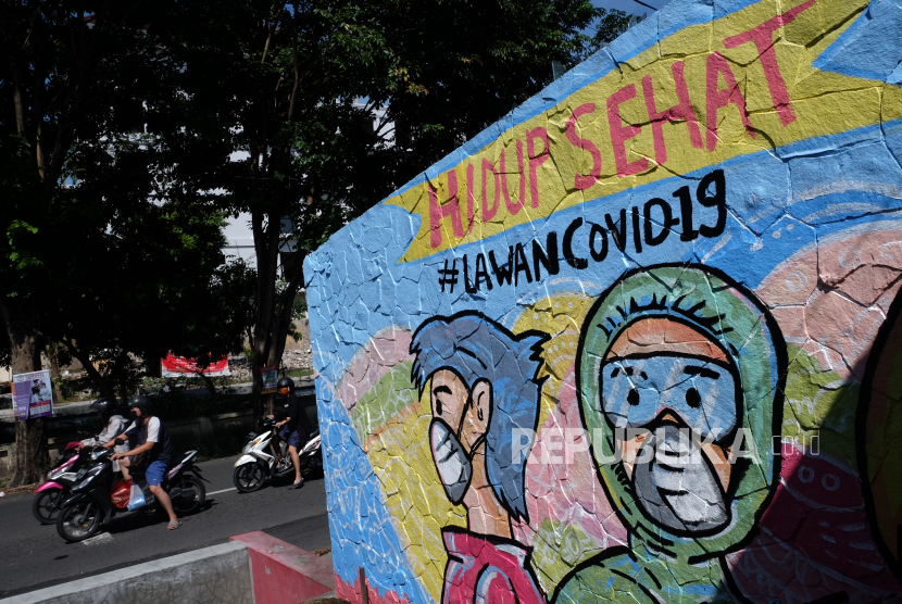 Warga melintas di depan mural bertema Hidup Sehat Lawan Covid-19 di Serengan, Solo, Jawa Tengah (Ilustrasi). Satuan Polisi Pamong Praja (Satpol PP) Kota Surakarta menyayangkan banyaknya balita yang masih mengunjungi taman-taman kota di masa pandemi Covid-19.
