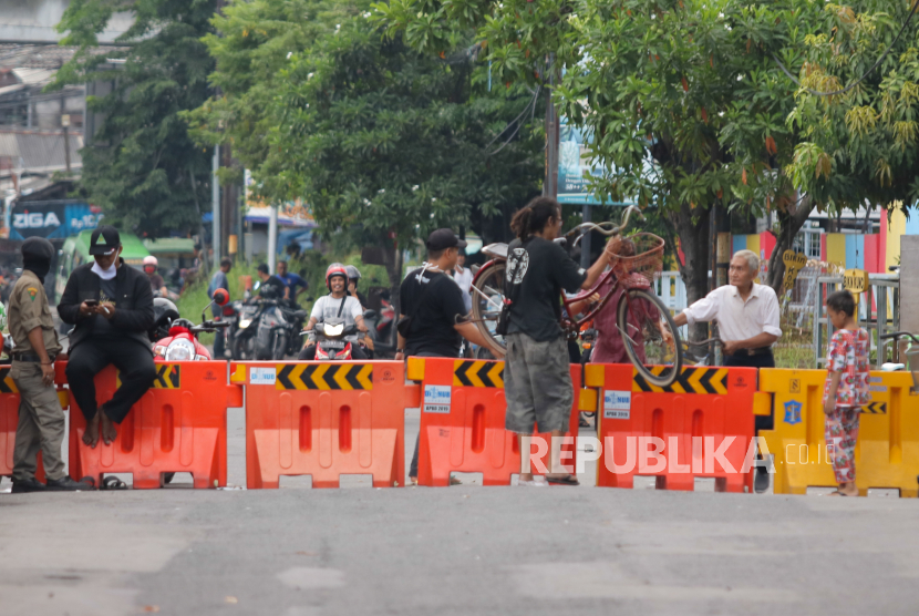 Warga beraktivitas di Jalan Rungkut Menanggal, Surabaya, Jawa Timur, Ahad (5/4/2020). Warga setempat menutup jalan penghubung Kota Surabaya-Sidoarjo itu untuk memutus penyebaran Virus Corona (COVID-19)