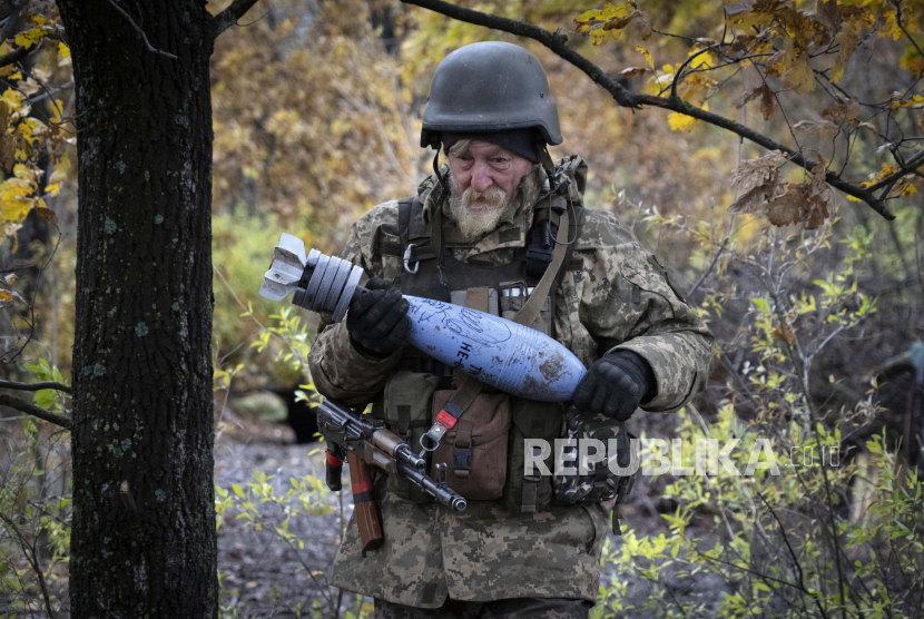  Seorang tentara Ukraina membawa selongsong peluru berisi pesan tertulis kepada tentara Rusia, di posisi garis depan dekat Bakhmut, di wilayah Donetsk, Ukraina, Kamis, 27 Oktober 2022.