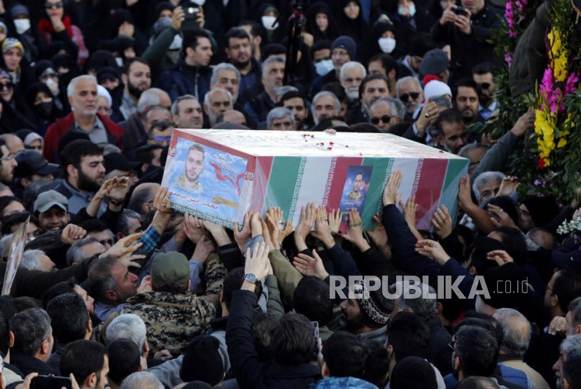 Orang-orang membawa peti mati anggota Korps Pengawal Revolusi Islam Iran (IRGC) Mohammad Amin Samadi saat upacara pemakaman di Teheran, Iran, (22/1/2024).