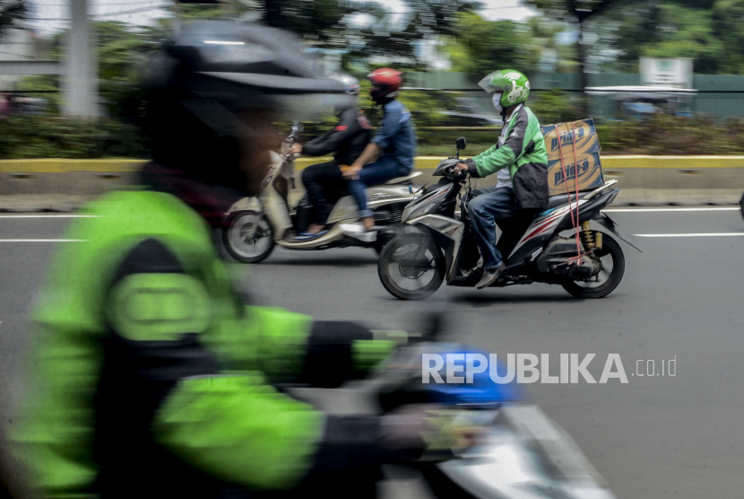 Sejumlah pengemudi ojek online membawa barang pesanan di Jalan Kramat Raya, Senen, Jakarta, Senin (13/4). Masih belum jelasnya regulasi antara Peraturan Menteri Perhubungan dan Peraturan Menteri Kesehatan terkait diperbolehkanya ojek online membawa penumpang selama masa Pembatasan Sosial Berskala Besar (PSBB) membuat pengemudi ojek online hanya bisa membawa barang pesanan selama masa pandemi COVID-19