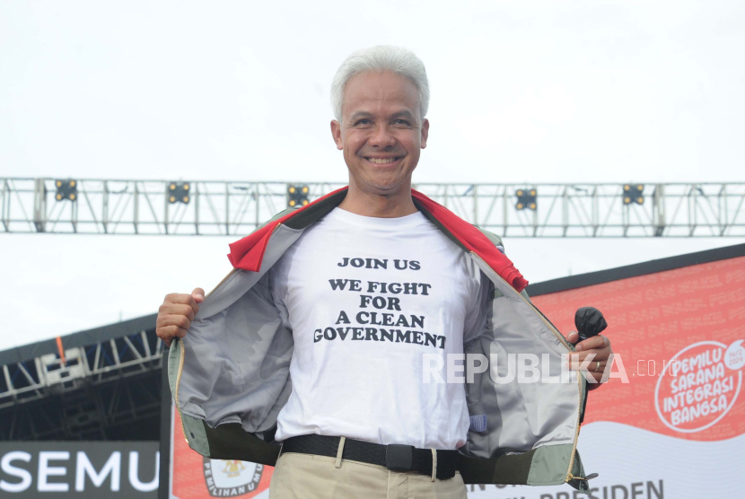 Nomor urut 3 Ganjar Pranowo membuka jaket menunjukkan tulisan dikaos saat kampanye akbar penutup di Semarang, Jawa Tengah di Lapangan Pancasila Simpang Lima, Semarang, Jawa Tengah, Sabtu (10/2/2024).