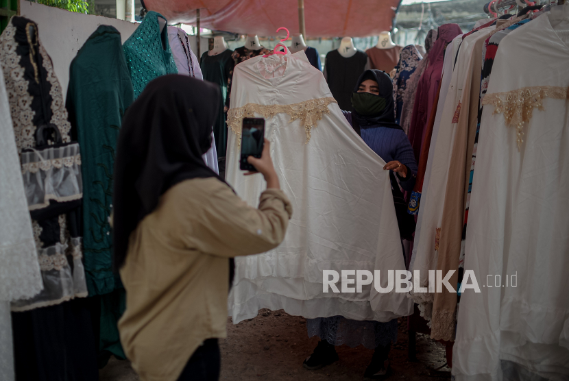 Etty Suhayati (50) pedagang di pasar Ramayana Tasik Tanah Abang mengambil gambar untuk dijual secara online di Jakarta, Rabu (18/8). Kementerian Koperasi dan UKM (Kemenkop) mencatat, per Juli 2021 sudah ada sebanyak 15,3 juta UMKM yang melakukan digitalisasi. 