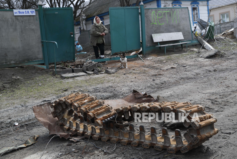 Tetiana Oleksienko, 69, berdiri di gerbang rumahnya, di desa Andriivka, Ukraina, pada Rabu, 6 April 2022. Pihak berwenang Ukraina mengumpulkan orang-orang yang tewas dan mengumpulkan bukti kekejaman Rusia di pinggiran Kyiv yang hancur. 