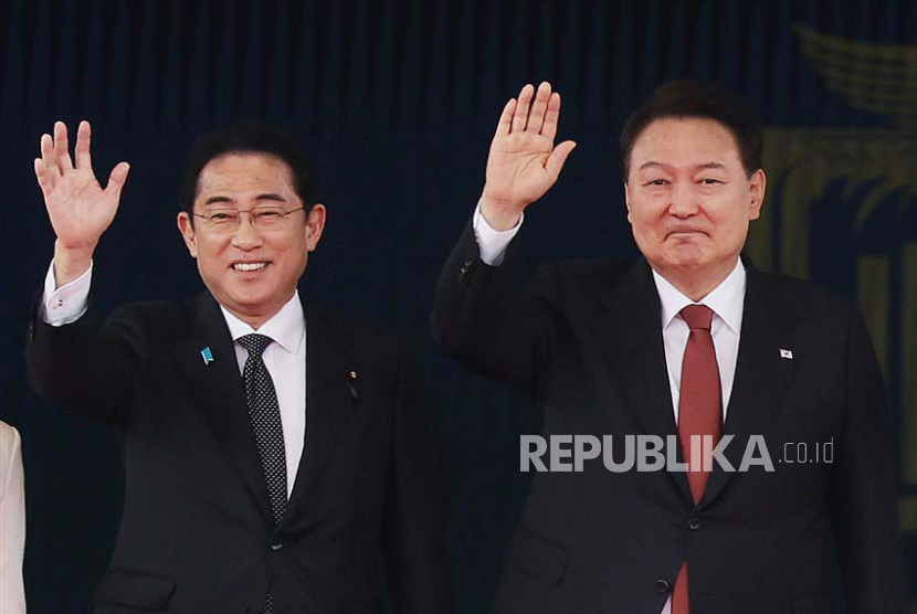 Presiden Korea Selatan Yoon Suk Yeol (kanan) dan Perdana Menteri Jepang Fumio Kishida melambai saat upacara penyambutan pemimpin Jepang di kantor kepresidenan di Seoul, Ahad (7/5/2023). Kishida berada di Korea Selatan untuk kunjungan dua hari untuk mempererat hubungan antara kedua negara.
