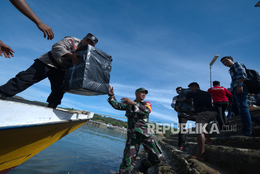 Personel kepolisian dan TNI Angkatan Darat dan warga menaikan logistik Pemilu 2024 diatas perahu yang telah dibungkus plastik untuk didistribusikan di Pulau Saponda Laut, Kecamatan Soropia, Kabupaten Konawe, Sulawesi Tenggara, Senin (12/2/2024). 