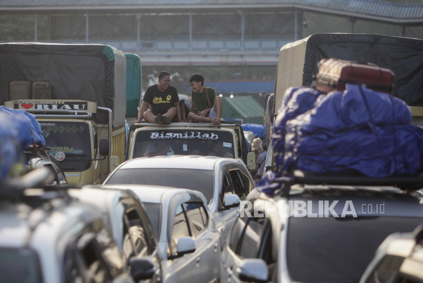 Pemudik duduk diatas mobil saat mengantre untuk memasuki kapal ferry di Pelabuhan Merak, Cilegon, Banten, Ahad (7/4/2024). 