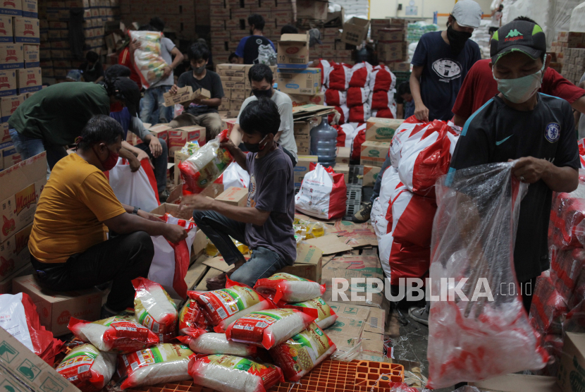 Pekerja mengemas paket bantuan sosial di gudang PT Food Station Tjipinang Jaya, Cipinang, Jakarta Timur, Senin (18/5/2020). 