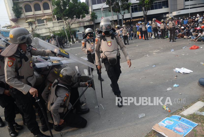 Petugas kepolisian berjaga ditengah para demonstran yang menggelar aksi menolak UU Cipta Kerja atau Omnibus Law di kawasan Harmoni, Jakarta, Kamis (8/10).