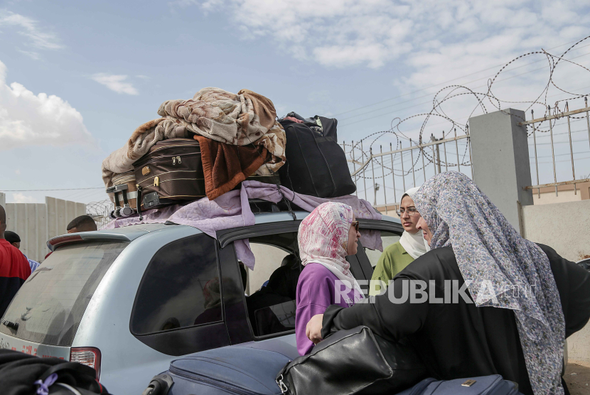 Warga Palestina dengan kewarganegaraan ganda menunggu untuk melintasi perbatasan Rafah dengan Mesir, Jalur Gaza selatan, Senin (16/10/2023).
