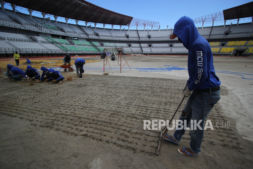 Pekerja membuat lubang untuk pemasangan bibit rumput di lapangan Stadion Gelora Bung Tomo (GBT), Surabaya, Jawa Timur, Jumat (18/9/2020). Sejumlah perbaikan di stadion tersebut terus dikejar guna mendukung sarana dan prasarana perhelatan Piala Dunia U-20 yang akan diselenggarakan pada tahun 2021 mendatang. 