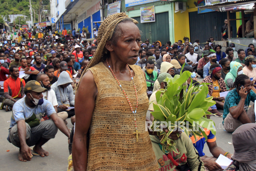 Seorang mama-mama Papua melintasi ratusan mahasiwa yang mengikuti aksi di Lingkaran Abe, Distrik Abepura, Kota Jayapura, Papua, Jumat (1/4/2022). Aksi tersebut untuk menolak pemekaran Daerah Otonomi Baru (DOB) di Papua. 