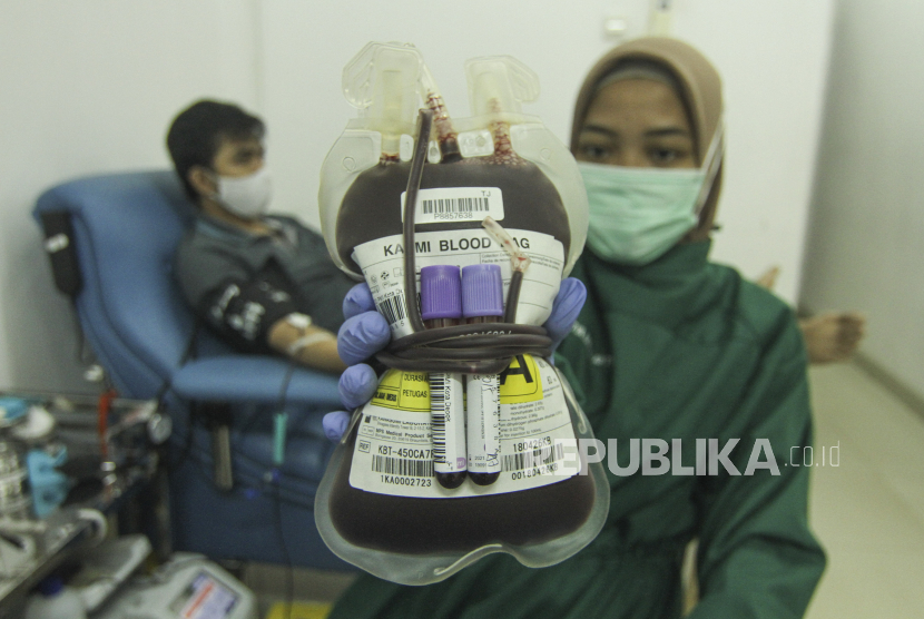 Petugas Palang Merah Indonesia (PMI) menunjukkan kantong berisi darah pendonor di ruang layanan donor darah PMI Kota Depok, Jawa Barat.