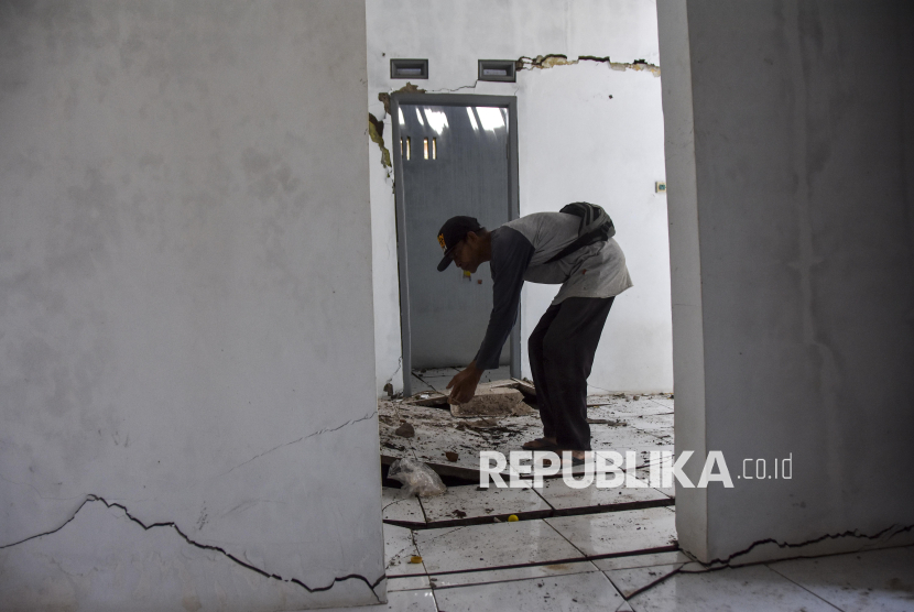 Warga menunjukkan tembok rumah yang retak akibat pergerakan tanah di Desa Cikondang, Kabupaten Tasikmalaya, Jawa Barat, Selasa (18/2/2025). Sebanyak 43 rumah warga retak akibat pergerakan tanah dan 48 Kepala Keluarga (KK) terpaksa mengungsi di rumah saudaranya dan posko pengungsian. 