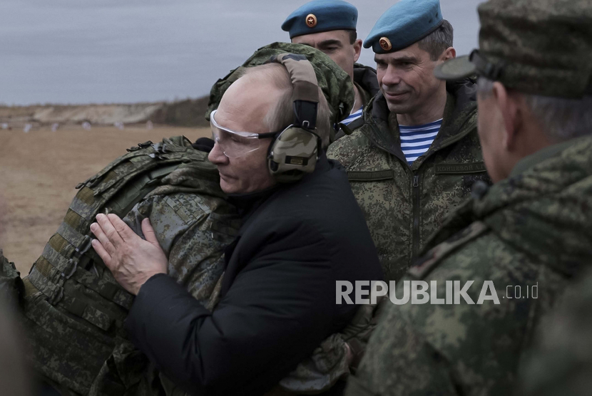 Dalam foto selebaran yang dirilis oleh Layanan Pers Kementerian Pertahanan Rusia ini, Presiden Rusia Vladimir Putin, tengah, memeluk seorang tentara saat ia mengunjungi pusat pelatihan militer Distrik Militer Barat untuk mengerahkan pasukan cadangan di Wilayah Ryazan, Rusia, Kamis, 20 Oktober 2022 .