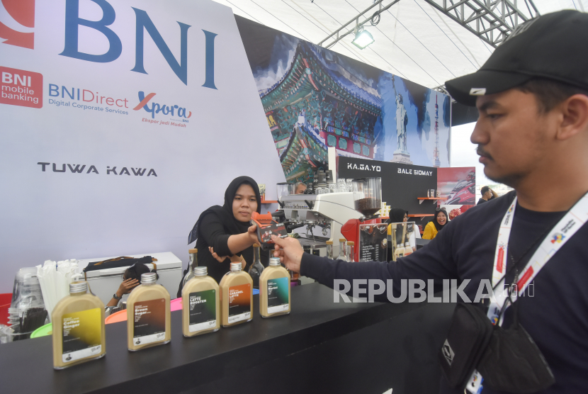 Pengunjung melakukan pembayaran menggunakan TapCash BNI di sebuah stan UMKM yang menjual produk lokal di area tribun Sirkuit Mandalika di Desa Kuta, Praya, Lombok Tengah, NTB, Sabtu (12/11/2022). Guna mendorong pelaku UMKM untuk ikut berdaya dan lebih dikenal dikancah internasional sekaligus mendukung gelaran World Superbike Mandalika (WSBK) 2022, BNI menghadirkan stan UMKM yang menjual berbagai produk kerajinan tangan, kopi, makanan dan minuman lokal. 